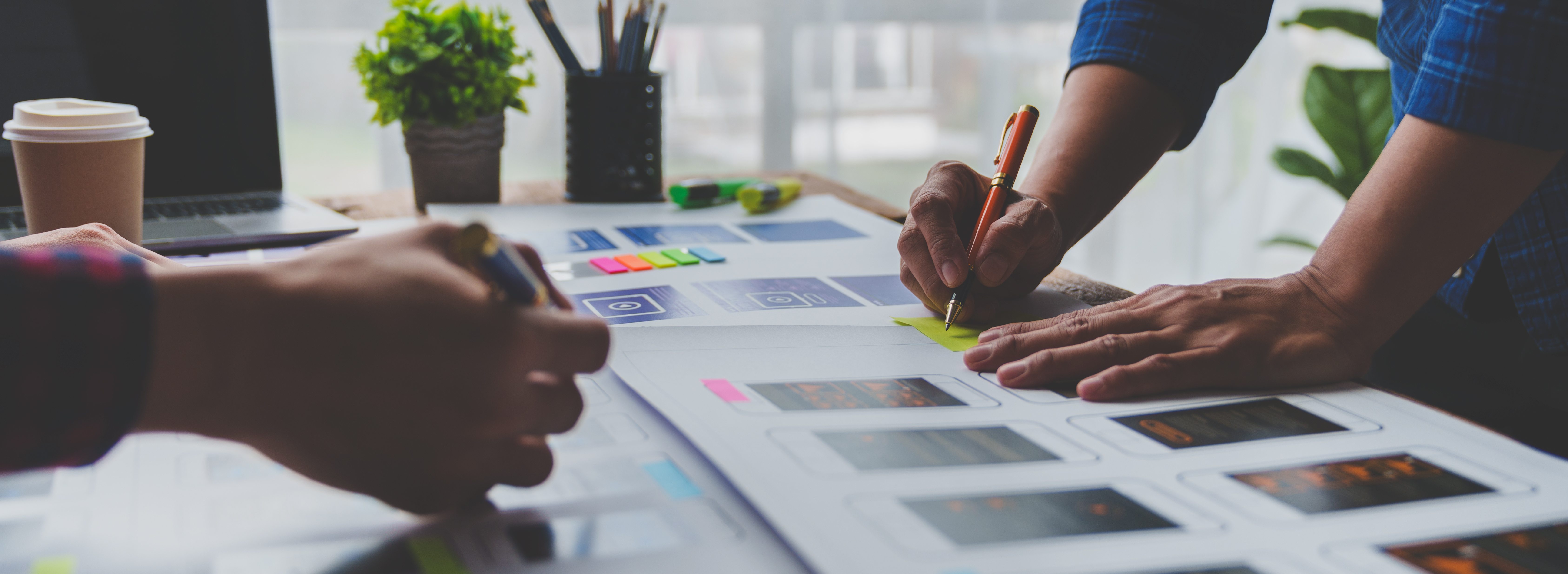 A creative agency team planning social content layouts at a studio desk